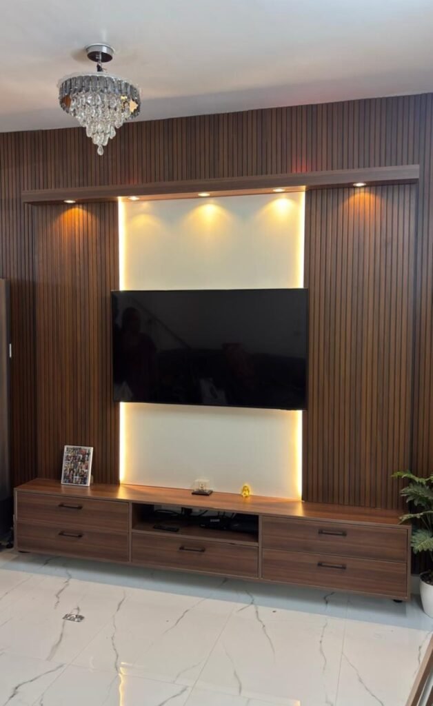 Wood-panelled TV unit with backlight by Evolve Decors, Chennai